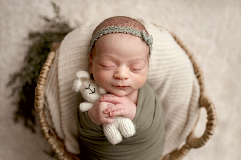Baby girl wrapped in green holding bunny during her Ellicott City Newborn Photography Session