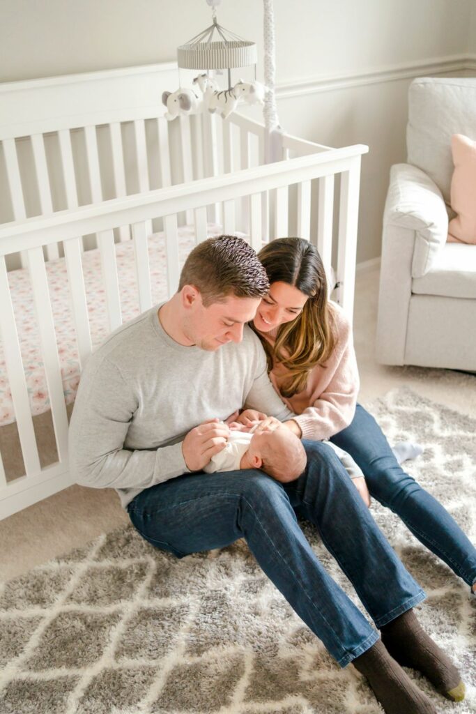 Parents holding baby in her nursery during their Lifestyle Newborn Photography Session in their Ellicott City home
