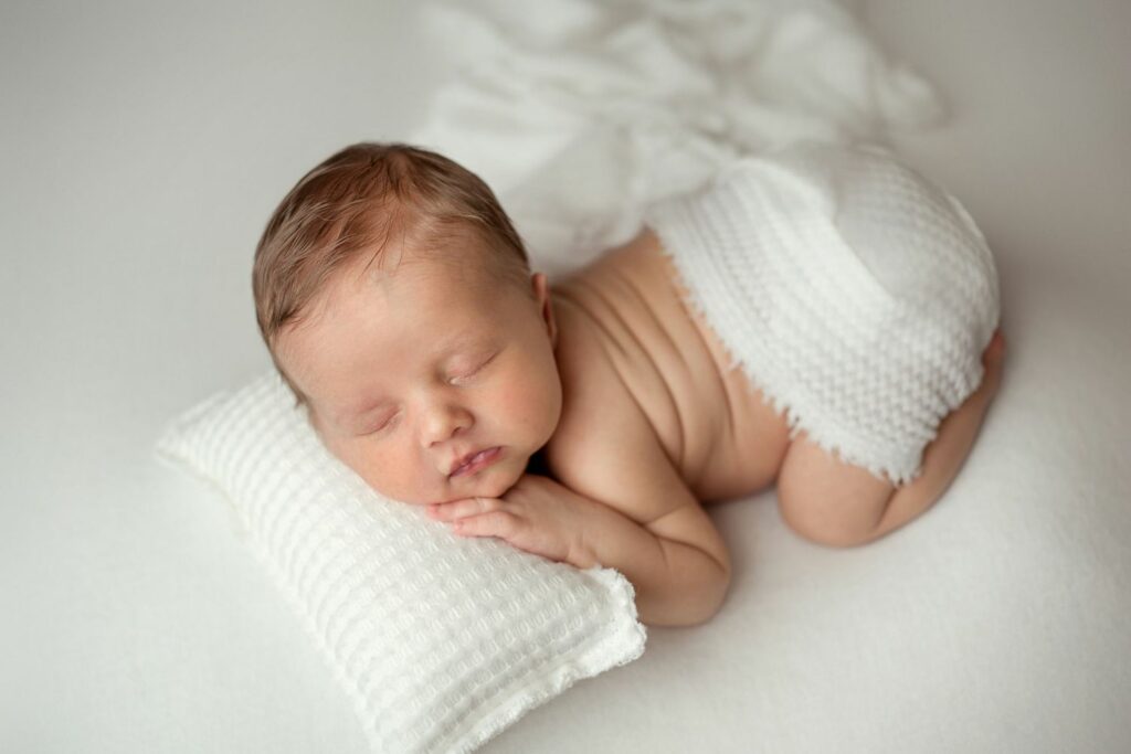 Baby boy posed on white setup during his Newborn Photography Session in Columbia, MD
