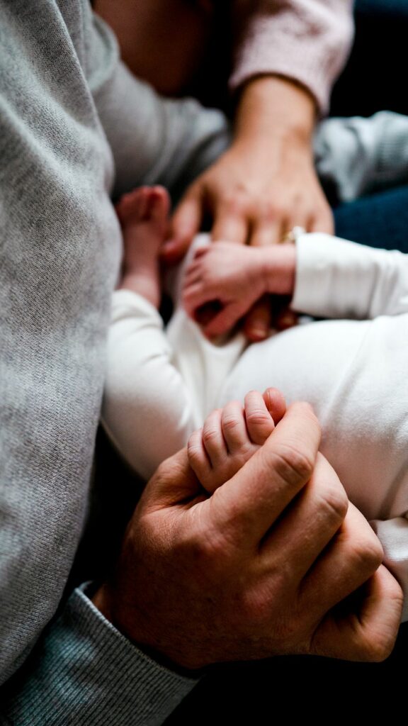 Baby and parents hands close up during Lifestyle Newborn Photography Session in their Ellicott City home