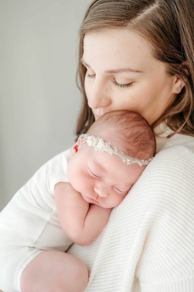 Close up image of mom holding baby girl against her shoulder in their Sykesville home by Maryland Newborn Photographer Melissa Porta