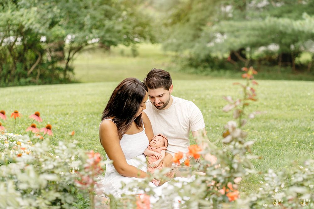 Parents with their newborn in their garden during a Lifestyle Photo Session in Howard County, MD