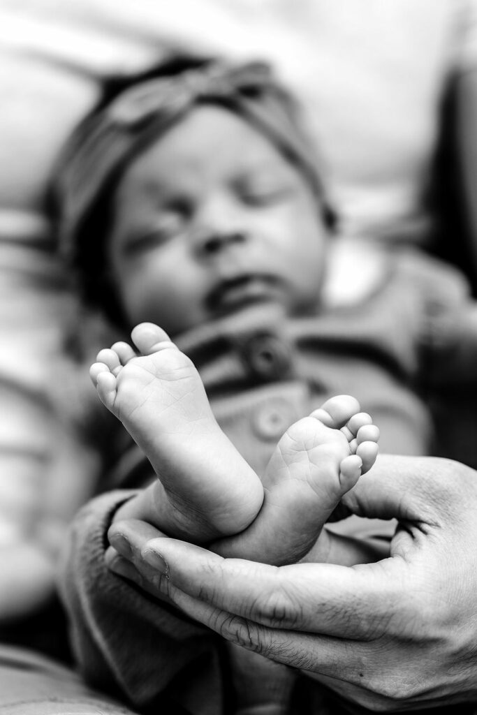 Black and white image of baby's feet during a Lifestyle Newborn Session in Howard County