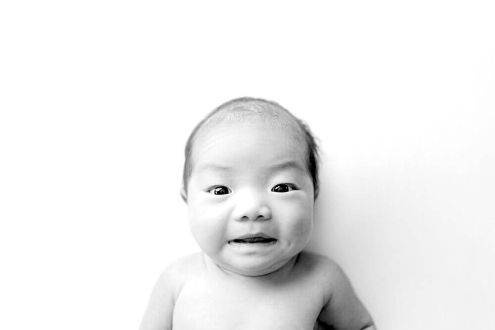 Black and white expression image of awake baby in her Olney, MD Newborn Photo Session