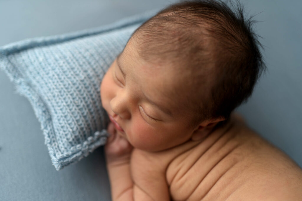 Clarksville baby boy sleeping on pillow posed for newborn photoshoot