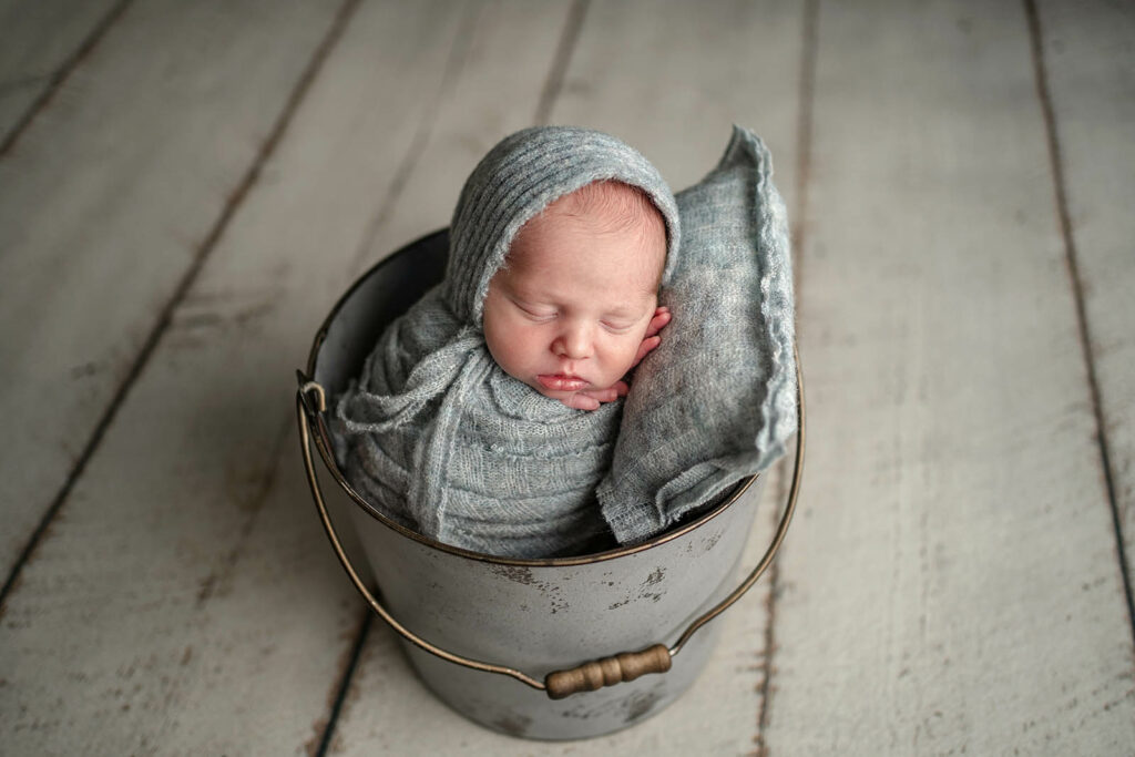 Ellicott City MD Photography session featuring newborn wrapped in grey blue color in coordinating bucket